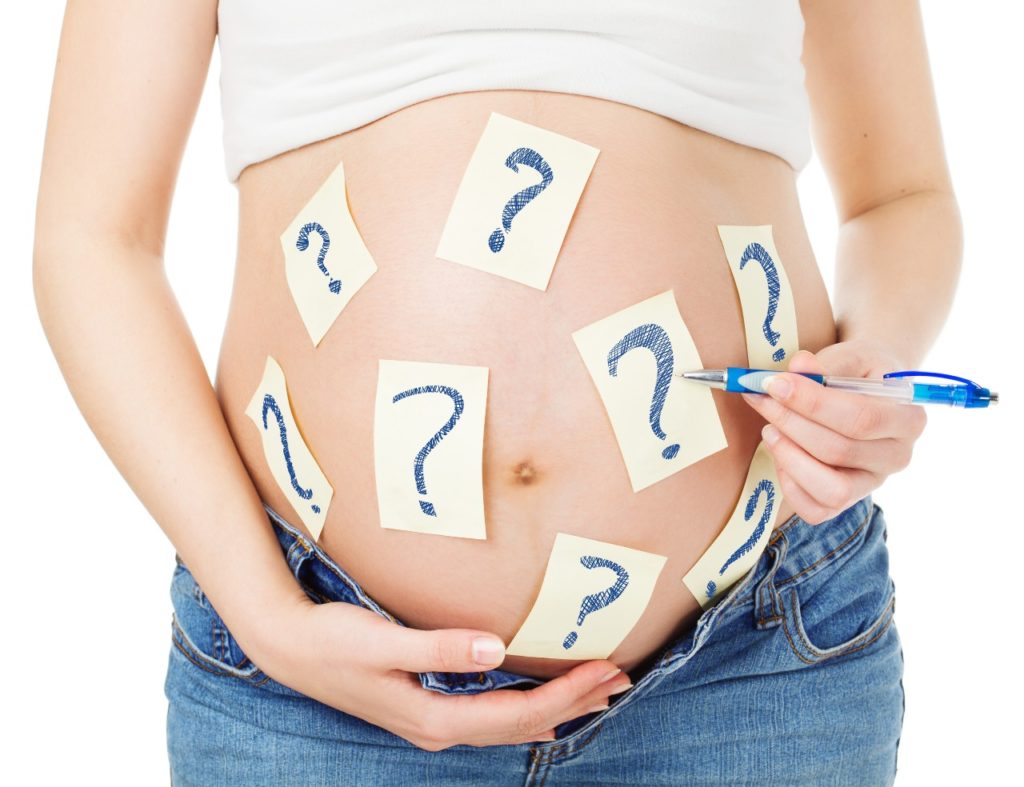 Pregnant stomach with question marks on it.