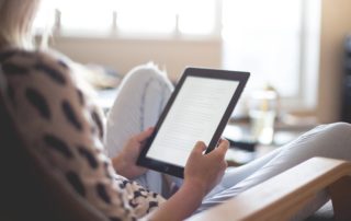 A person sitting and reading on their ipad.