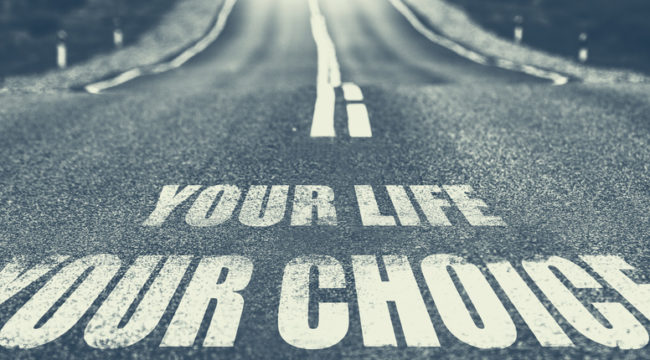 A road that says "Your life, your choice" on the asphalt.